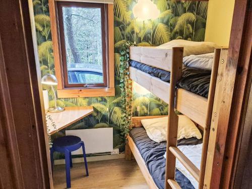 a room with bunk beds and a desk and a window at 4 star holiday home in Ry in Ry
