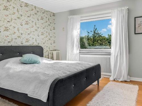 a bedroom with a large bed and a window at 6 person holiday home in Borre in Borre