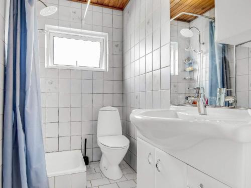 a white bathroom with a toilet and a sink at 6 person holiday home in Borre in Borre