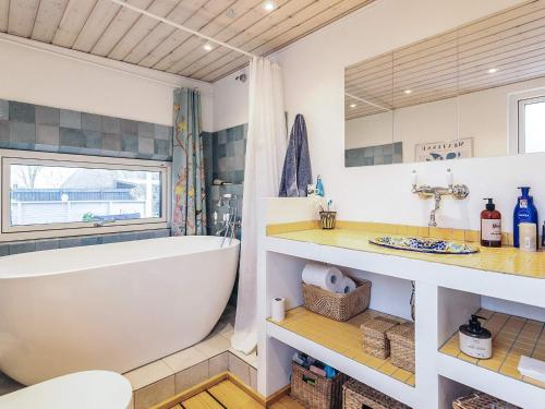 a bathroom with a large white tub and a sink at 6 person holiday home in Rude in Rude