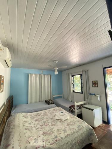 a bedroom with a large bed with a white ceiling at Pousada Ypê Amarelo in Itatiaia