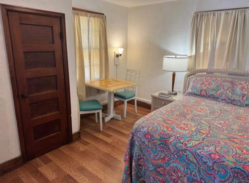 a bedroom with a bed and a table and a desk at Crescent Court in Branson