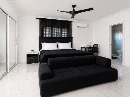 a bedroom with a black bed and a couch at Redhills Escape in Kingston