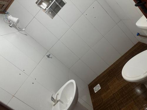 a white bathroom with a toilet and a sink at El Regreso in Chuí