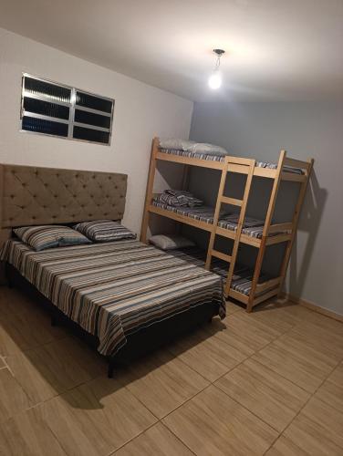 a bedroom with two bunk beds and a ladder at Estância Serra Du Capiau 01 in Mairiporã