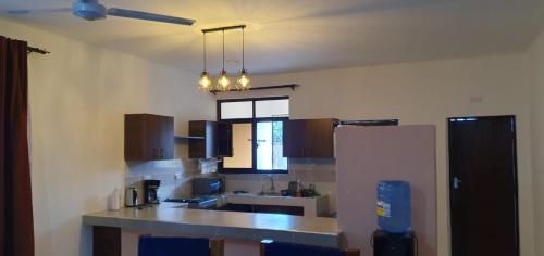 a kitchen with a counter top and a refrigerator at TajiS Diani Chic 1 BR with swimming pool in Diani Beach