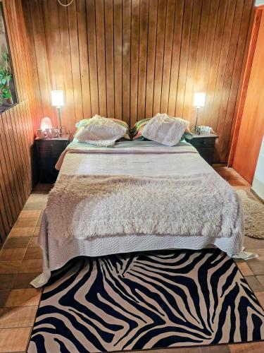 a bedroom with a bed with a zebra print rug at Reina Mar Jacuzzi Exclusivo in Barra de Portezuelo