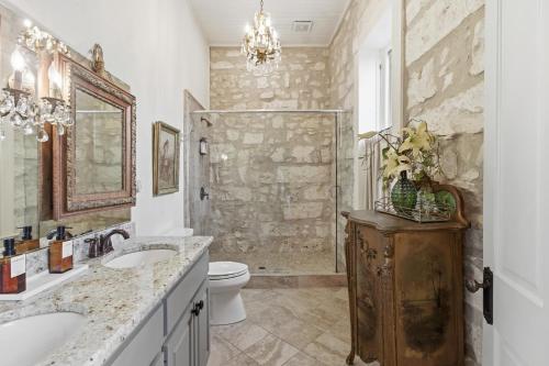 a bathroom with two sinks a toilet and a shower at Shopkeeper's Inn in Fredericksburg