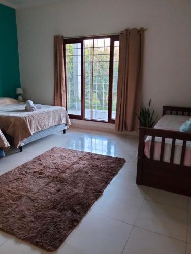 a bedroom with two beds and a large window at Suite Premium Perico Jujuy con Parking in Establecimiento La Candelaria