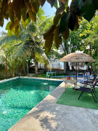 a swimming pool with a table and a umbrella at Casita Agnes Private Resort in Boac