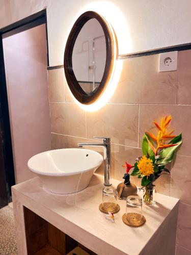 a bathroom with a sink and a mirror at The SUN House in Balian