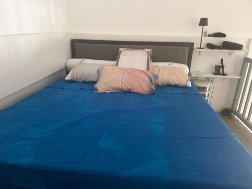 a bedroom with a blue bed with two pillows on it at stayhouse in Gapan