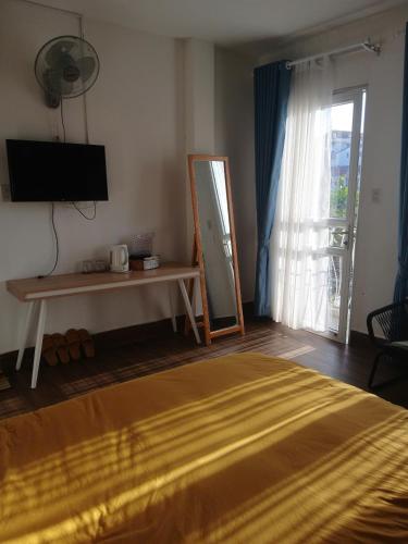a bedroom with a bed and a television and a window at MyHouse in Da Lat