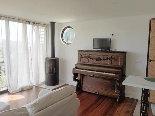 a living room with a piano and a couch at Villa Alba - Vitorino dos Piães in Navio