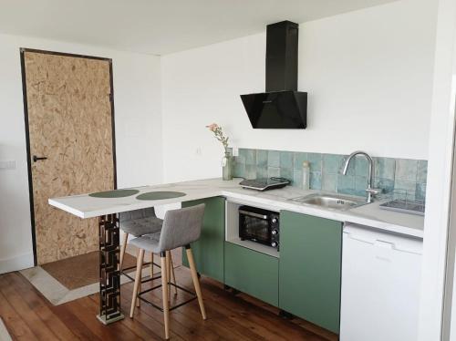 a kitchen with green and white counters and a sink at Villa Alba - Vitorino dos Piães in Navio