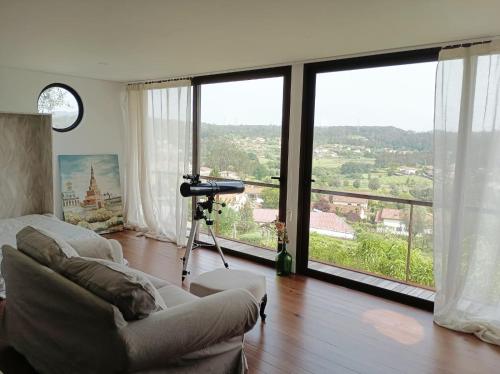 a living room with a couch and a large window at Villa Alba - Vitorino dos Piães in Navio