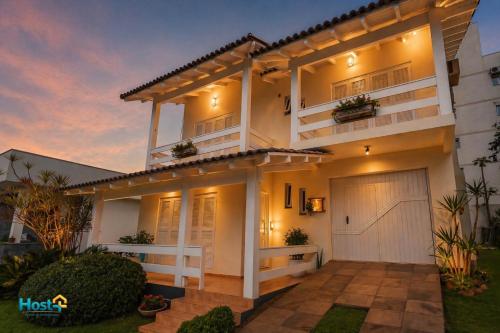 a large white house with a garage at dusk at Casa grande e aconchegante in Encantado
