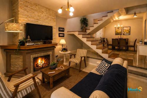a living room with a staircase and a fireplace at Casa grande e aconchegante in Encantado