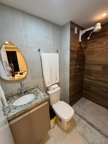 a bathroom with a toilet and a sink and a mirror at Carneiros Pernambuco in Tamandaré