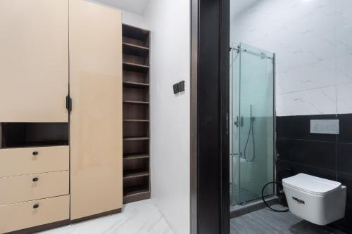 a bathroom with a toilet and a glass shower at Modern Luxury 2BR Spacious Cozy 24hr Power in Lekki