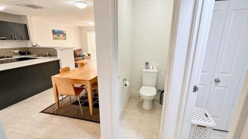 a kitchen and dining room with a table and a toilet at Escape to 39 at Cape View in Busselton