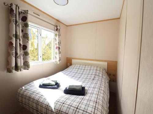 a bedroom with a bed with two towels on it at Cozy chalet with a view over the fields in Drachten