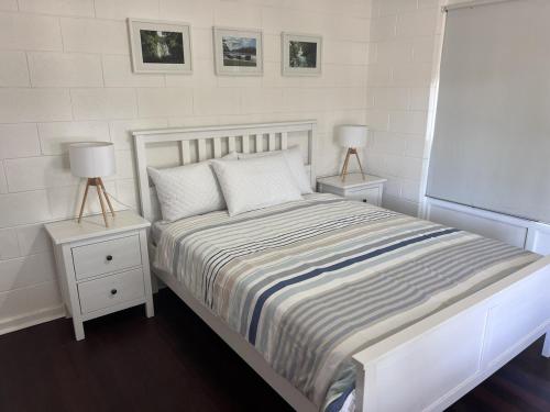 a white bed with two night stands and two lamps at 28 Ozone Victor Harbor in Victor Harbor