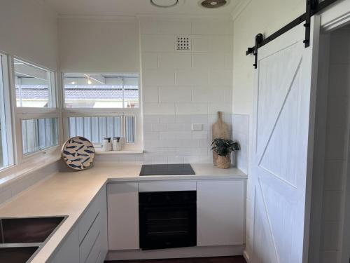 a white kitchen with a stove and a sink at 28 Ozone Victor Harbor in Victor Harbor