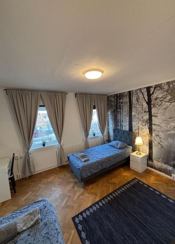 a bedroom with two beds and two windows at Spacious House for Families & Workers in Skelleftehamn