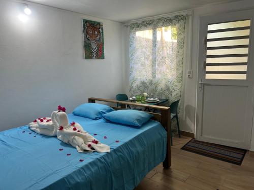 a bedroom with a blue bed with towels on it at Instant Locatif in Gourbeyre