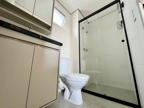 a bathroom with a toilet and a glass shower at Apartamento com vista Jd Higienopolis in Bauru