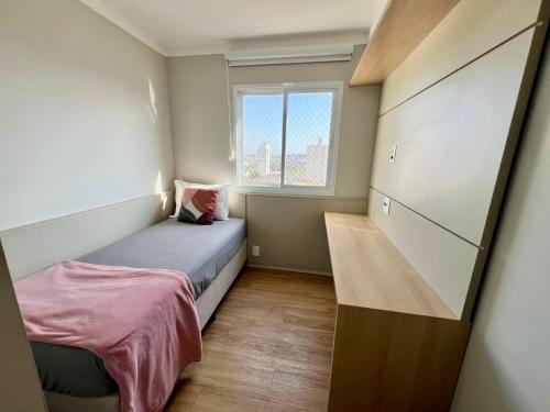 a small bedroom with a bed and a window at Apartamento com vista Jd Higienopolis in Bauru