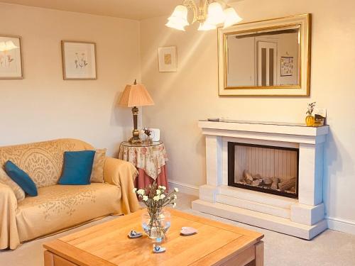 a living room with a couch and a fireplace at Tilly Cottage - overlooking Pendle Hill in Barrowford