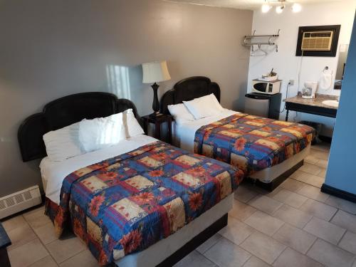 a hotel room with two beds and a desk at Chaparral Inn in Arcola