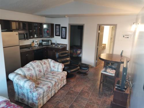 a living room with a couch and a kitchen at Chaparral Inn in Arcola