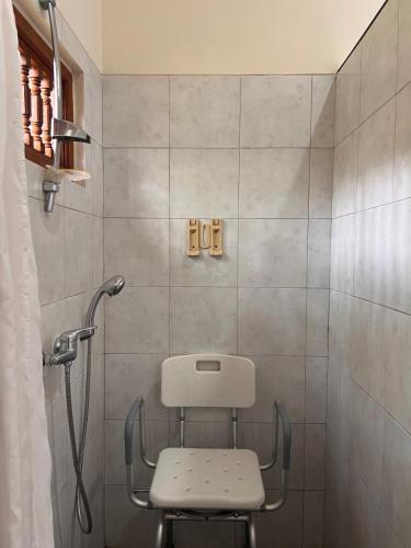 a shower with a chair in a bathroom at Our Bali Homestay in Ubud