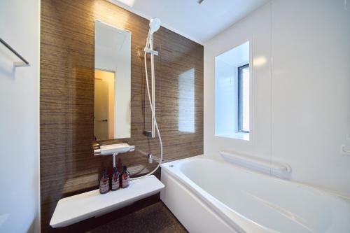 a bathroom with a white tub and a sink at TOMARIE Rooftop House Skytree in Tokyo