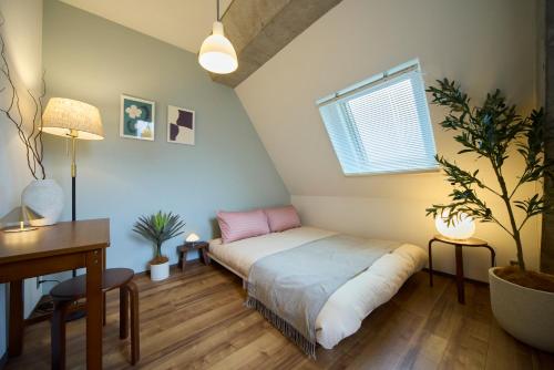a bedroom with a bed and a desk and a table at TOMARIE Rooftop House Skytree in Tokyo
