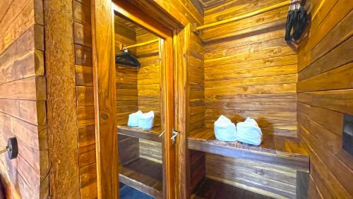 a wooden sauna with three white pillows in it at Paradise Beach Bacalar A Pie De Laguna in Bacalar