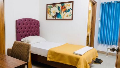 a small bedroom with a bed and a table at ROYAL INN in Trivandrum