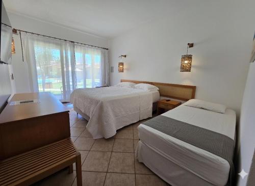 a hotel room with two beds and a table at Hotel Velejar in Cumbuco
