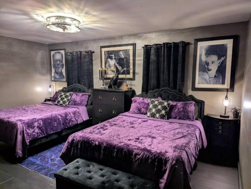 a bedroom with two beds with purple comforters at The Raven in Madison