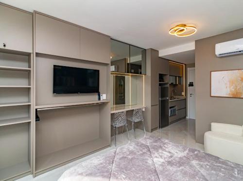 a living room with a flat screen tv and a living room at Studio 208 Premium 450m do Consulado EUA in Porto Alegre