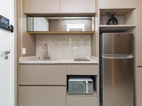 a kitchen with a sink and a refrigerator at Studio 208 Premium 450m do Consulado EUA in Porto Alegre