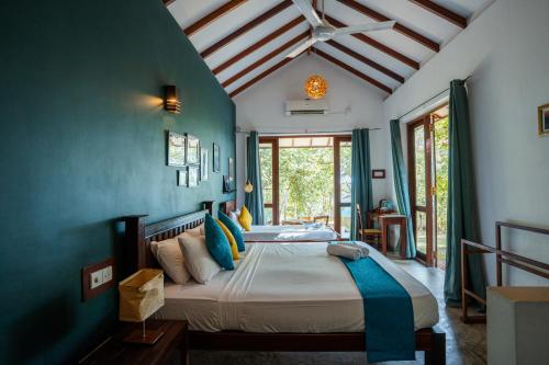 a bedroom with a large bed with blue walls at Ecoya Riverside Resort in Balapitiya