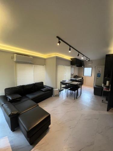 a living room with a black couch and a table at ATW Tokyo Near the station Close to Asakusa Airport For infants and toddlers in Tokyo