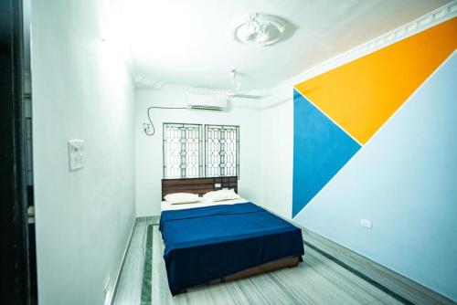 a room with a bed with a colorful wall at Classic Horizon in Mahabalipuram