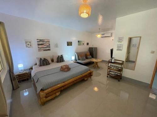 a bedroom with a large bed and a living room at Skott's Comfy Lodge in Bantayan Island