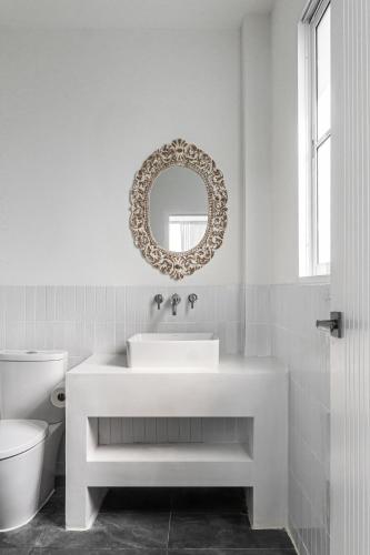 a white bathroom with a sink and a mirror at Blue Garden Villa A in Ban Madua Wan