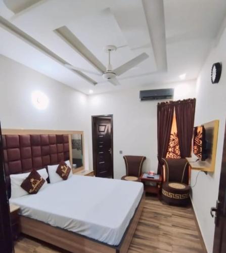 a bedroom with a bed and two chairs in it at Hotel Seven View Lahore in Lahore